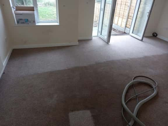 This is a photo of an empty living room with a brown carpet that is in the process of having its carpets steam cleaned works carried out by Beddington Carpet Cleaning