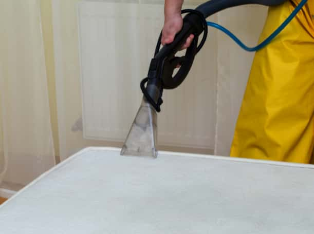 This is a photo of a man steam cleaning a dirty mattress works carried out by Beddington Carpet Cleaning